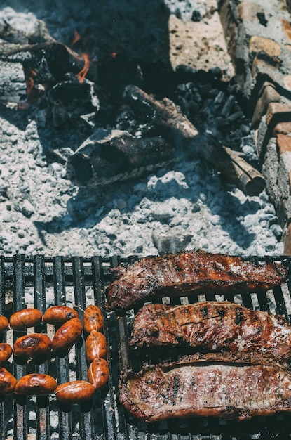 Foto lammkoteletts, die in einem grill mit chourizo geröstet werden