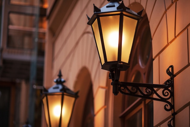 Lâmpada de rua à moda antiga à noite. lâmpadas de rua bem iluminadas ao pôr do sol. lâmpadas decorativas. lâmpada mágica com uma luz amarela quente no crepúsculo da cidade