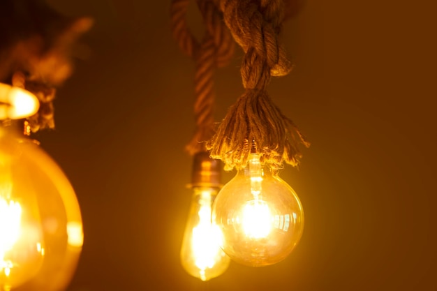 Lâmpada Edison, lâmpada Edison pendurada vintage sobre fundo escuro. Luzes de cor âmbar.