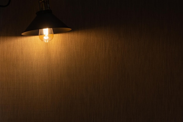 lâmpada elétrica vintage com uma sombra retrostyle ilumina um antigo loft de parede de tijolos