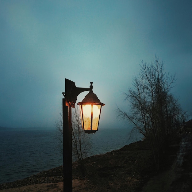 Foto lâmpada iluminada pelo mar contra o céu