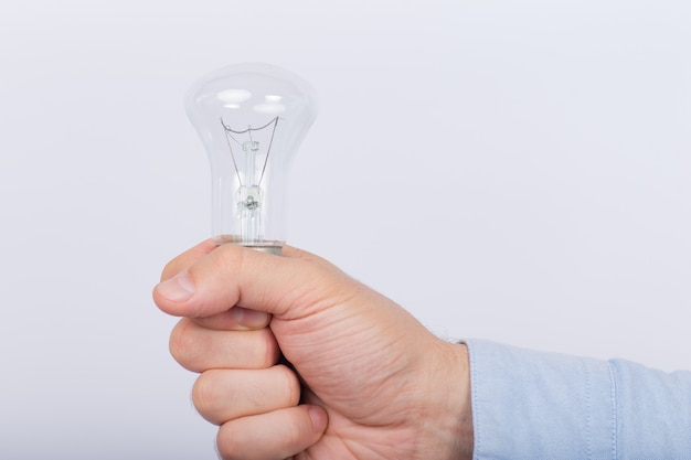 Lâmpada incandescente na mão masculina em branco.