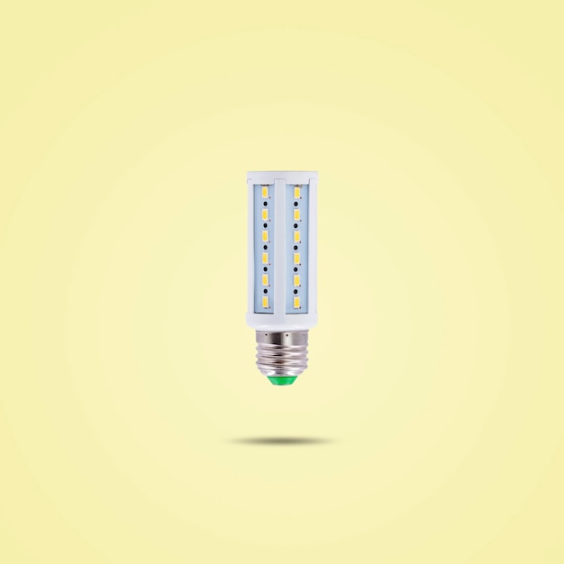 Lâmpada LED de economia de energia 230v isolada em fundo de cor pastel amarelo.