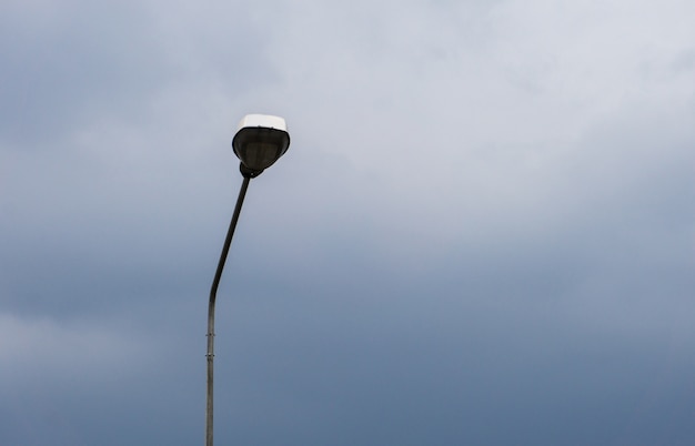 Lâmpada na rua com o céu de nuvem. Tempo crepuscular, lâmpada economiza energia, luz de fechamento