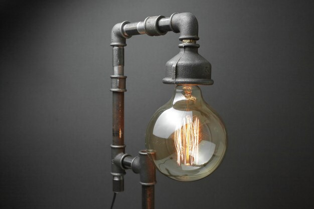 Lâmpada retro feita de canos de água de metal com uma lâmpada Edison.