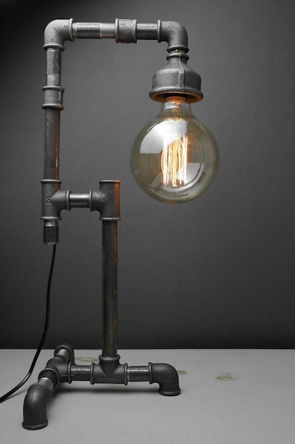 Lâmpada retro feita de canos de água de metal com uma lâmpada Edison.