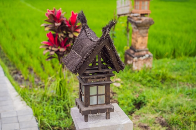 Lâmpada semelhante a uma pequena casa em bali entre um campo de arroz