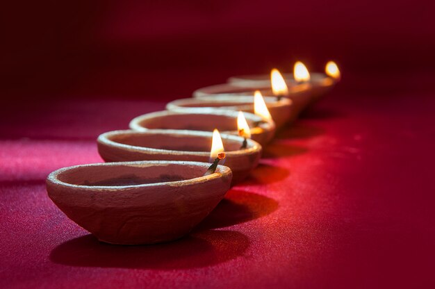 Lâmpadas de argila diya acesas durante a celebração de diwali. saudações cartão design indiano hindu light festival chamado diwali