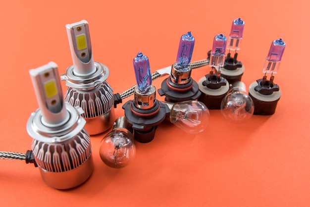Lâmpadas de carro de diferentes formas e tamanhos isoladas em laranja. Lâmpada de vidro automotivo moderno. Poder elétrico