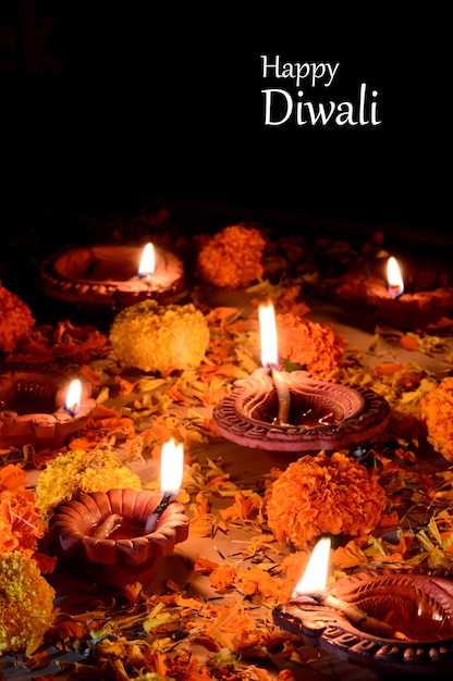 Lâmpadas diya de argila acesas durante a celebração do diwali. saudações festival hindu light festival indiano de design de cartão chamado diwali