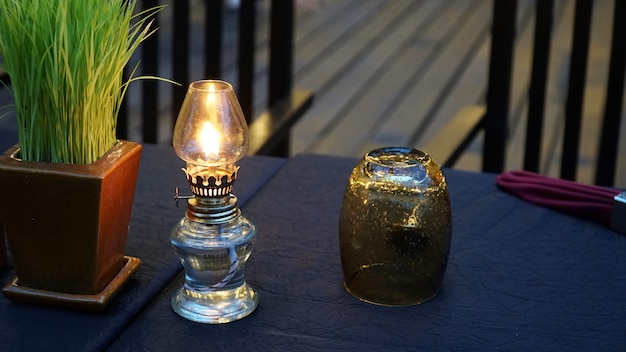 lámpara de aceite antigua y vidrio en la mesa