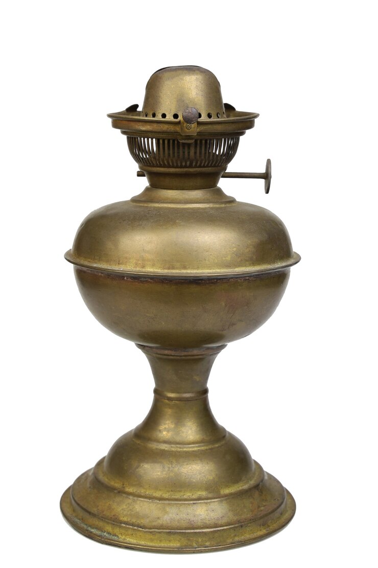 La lámpara de aceite de latón y bronce es de hierro viejo, mantiene el aceite y da luz en la noche en una herramienta antigua en Tailandia sobre fondo blanco.