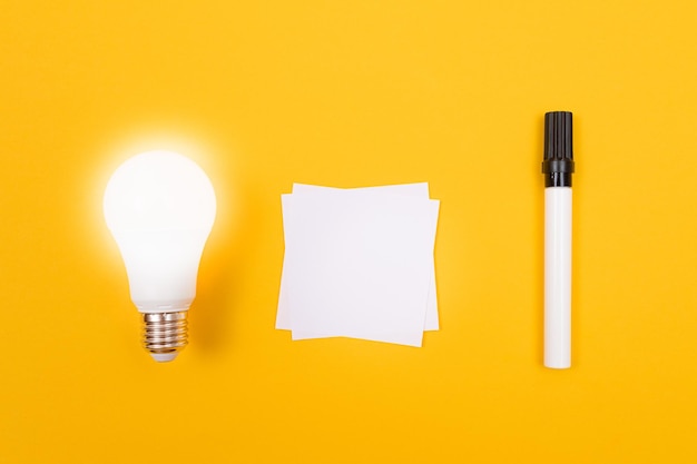 Foto lámpara de ahorro de energía incandescente con papel de nota blanco