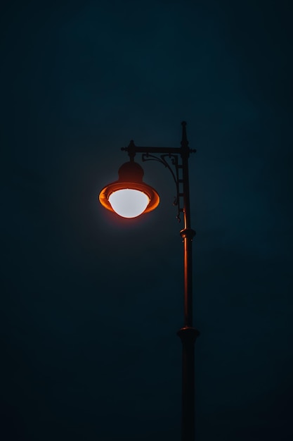 Lámpara de la calle en llamas contra el fondo del cielo nocturno