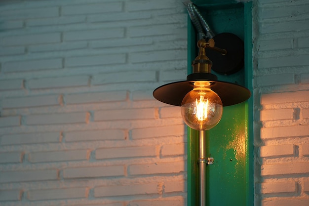 Lámpara edison LED vintage o bombilla incandescente en restaurante o cafetería con pared de bloques antiguos con tono marrón y naranja