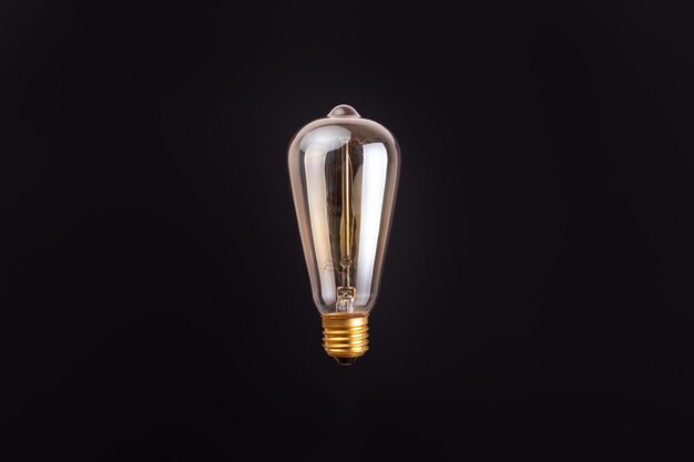 Foto lámpara edison sobre un fondo negro levitación con copyspace concepto ecología salvar el planeta tierra