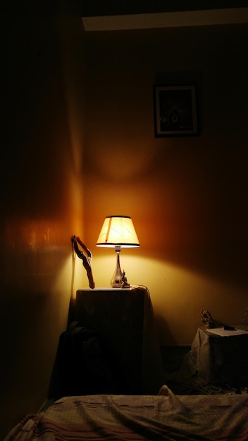 Lámpara iluminada en el cuarto oscuro en casa
