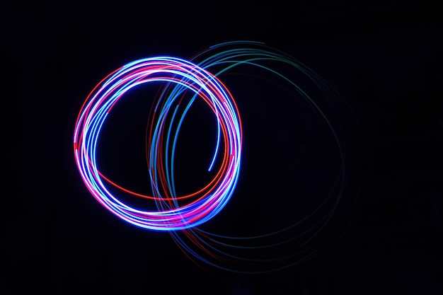 La lámpara de luz de color se mueve en tomas de larga exposición en la oscuridad.