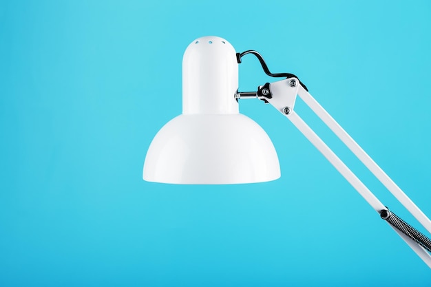 Lámpara de oficina de mesa blanca sobre fondo azul con espacio para texto y concepto de idea