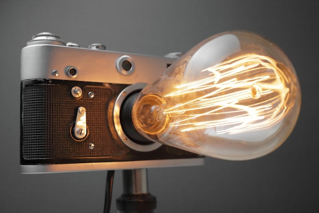 Lámpara retro de una vieja cámara con una lámpara Edison en gris