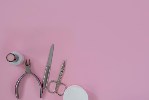 Lámpara ultravioleta y herramientas de manicura sobre un fondo rosa Manicura de esmalte de gel