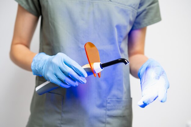 Foto lámpara uv en los dentistas mano en guantes de goma