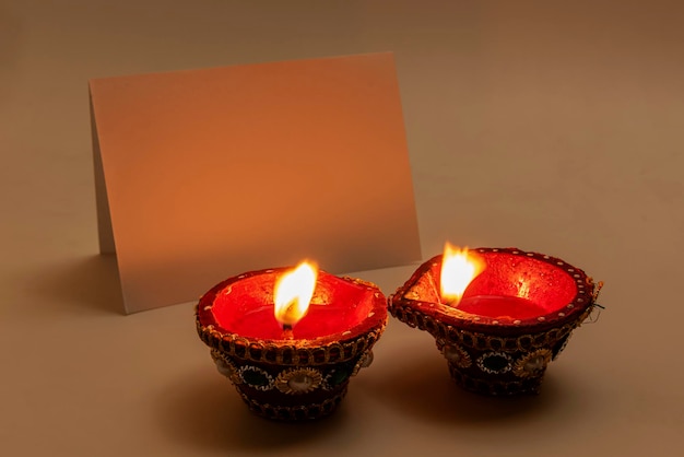 Lámparas de aceite Diya para el festival Diwali con papel vacío para copiar