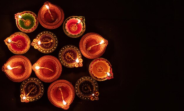 Lámparas de aceite Happy Diwali Diya sobre fondo oscuro