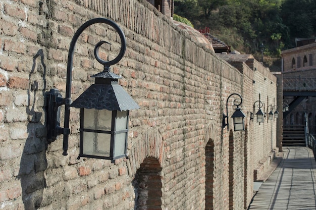Lámparas callejeras antiguas a lo largo de una pared de ladrillo