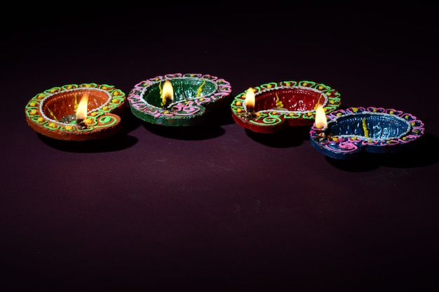 Lámparas Diya de arcilla de colores encendidas durante la celebración de Diwali. Diseño de tarjeta de saludos Festival de la luz hindú hindú llamado Diwali.