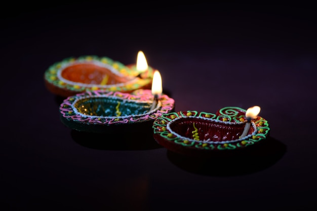 Lámparas Diya de arcilla de colores encendidas durante la celebración de Diwali. Diseño de tarjeta de saludos Festival de la luz hindú hindú llamado Diwali.