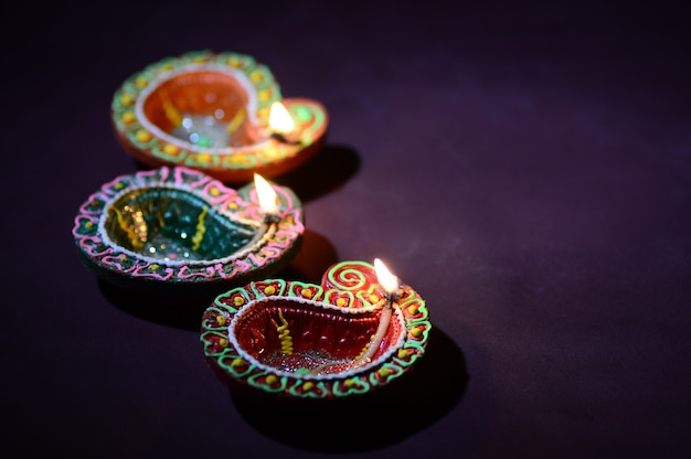 Lámparas Diya de arcilla de colores encendidas durante la celebración de Diwali. Diseño de tarjeta de saludos Festival de la luz hindú hindú llamado Diwali.