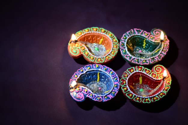 Lámparas Diya de arcilla de colores encendidas durante la celebración de Diwali. Diseño de tarjeta de saludos Festival de la luz hindú hindú llamado Diwali.