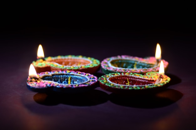 Lámparas Diya de arcilla de colores encendidas durante la celebración de Diwali. Diseño de tarjeta de saludos Festival de la luz hindú hindú llamado Diwali.