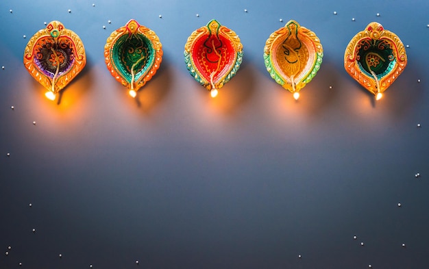 Foto lámparas happy diwali clay diya encendidas durante la celebración del festival hindú diwali de las luces lámpara de aceite tradicional colorida diya sobre fondo oscuro