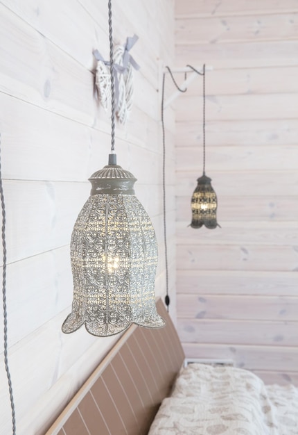 Lámparas vintage colgadas en una pared de madera blanca