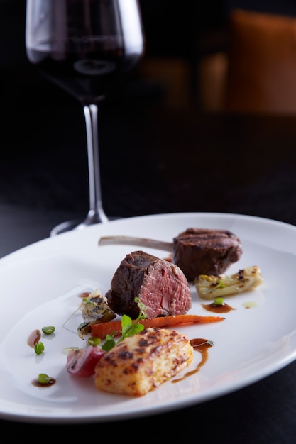 Lampensteak mit Rotwein auf schwarzem Tisch