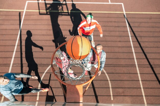 Lançamento perfeito. Vista superior de uma bola laranja caindo na cesta durante o jogo de basquete