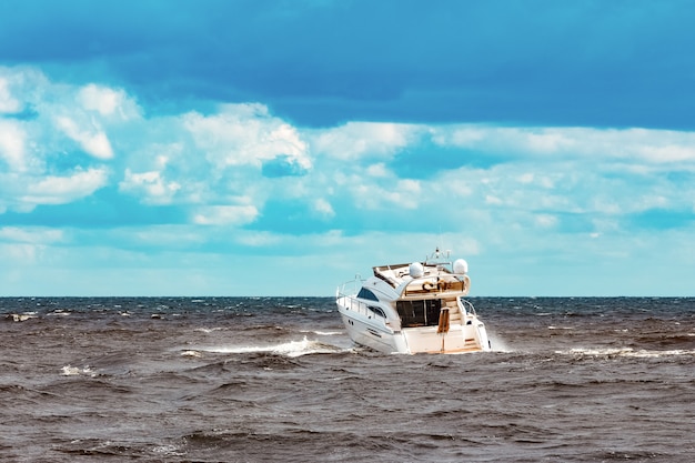 Lancha blanca moviéndose rápidamente hacia el mar Báltico. Deporte acuático