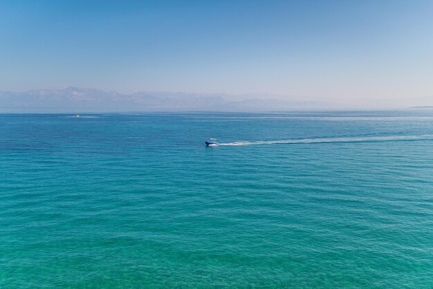 Lancha navegando en el mar contra el horizonte bajo un cielo azul