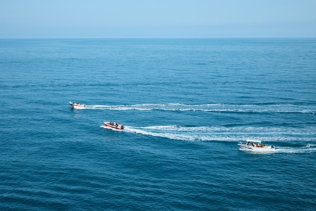 Lanchas a motor con pasajeros en el mar, un recorrido por el mar, rocas y montañas.