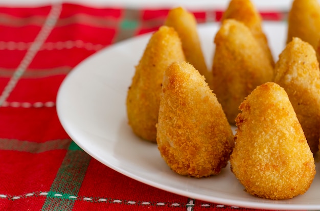 Lanche brasileiro. A coxinha é um salgadinho brasileiro, de origem paulista, também comum em Portugal, feito com massa de farinha de trigo e caldo de galinha