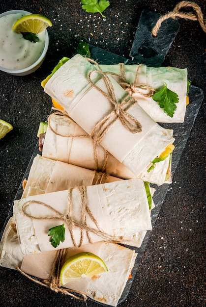Lanche de almoço saudável. pilha de tortilla de fajita de comida de rua mexicana envolve com filé de frango grelhado de búfalo e legumes frescos