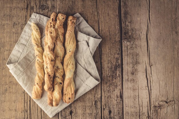 Foto lanche de palitos de pão grissini em um fundo de madeira tapas bar palitos de pão caseiro