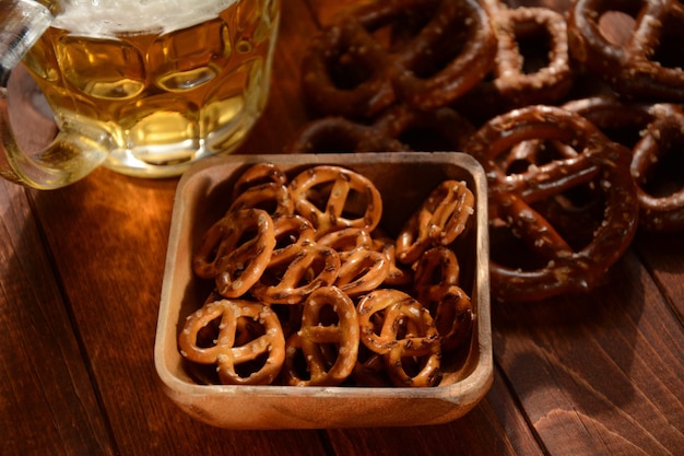 Lanche de pretzels duros ou pretzels salgados para festa na mesa de madeira rústica com copo de cerveja