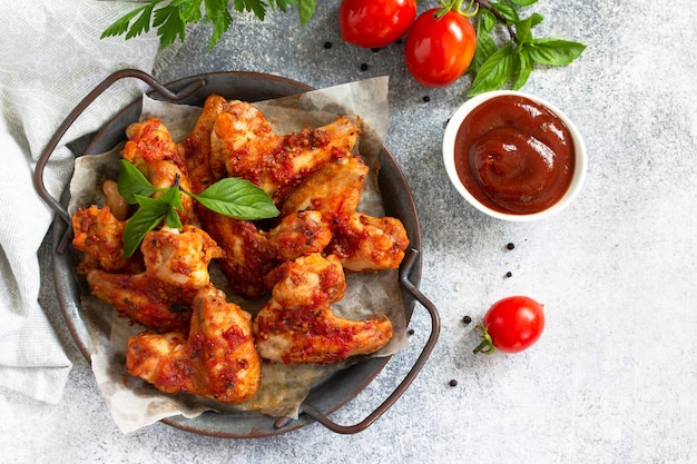 Lanche saboroso Asas de frango assado com molho de mostarda e tomate em uma mesa de concreto Vista superior