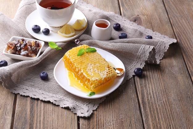 Lanche saudável com mel fresco na mesa de madeira