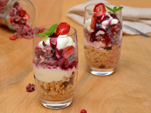 Lanche saudável de granola com iogurte natural e frutas em copos