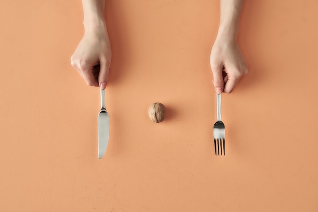 Foto lanche saudável de noz e mãos com garfo e faca isolado