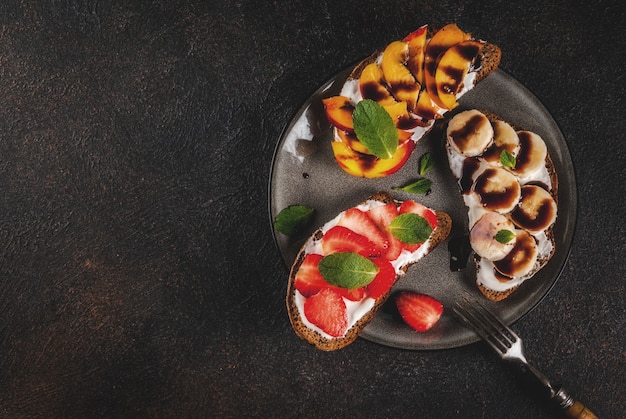 Lanche saudável do café da manhã de verão Sanduíches de torrada de centeio com frutas e bagas